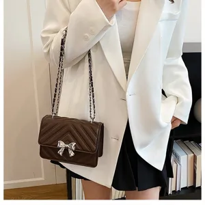 Brown quilted chain shoulder bag with silver bow accent, elegant daily cross-body purse.