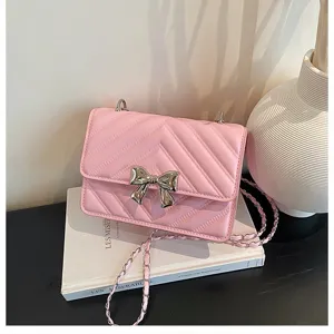Detailed shot of the elegant pink quilted chain shoulder bag featuring a silver bow accent.