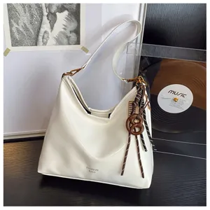 White PU leather shoulder bag detail, stylish hobo design with rope pendant and smooth finish.