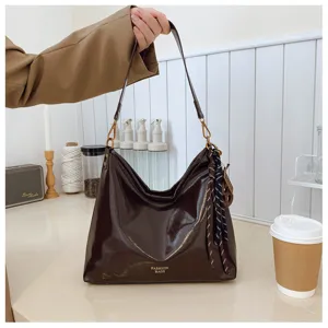 Close-up detail of retro brown leather shoulder bag with chic ribbon accent for women.