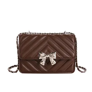 Women brown quilted chain crossbody bag with metallic bow, elegant shoulder bag for daily wear.
