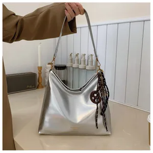 Silver metallic shoulder bag for women, retro casual commuter hobo bag with charm.