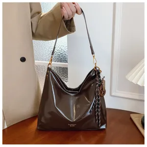Retro patent leather shoulder bag for women, stylish commute hobo handbag with tassel decor.