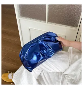 Vue détaillée d'un sac clutch nuage plissé en métal bleu élégant, montrant sa texture unique.