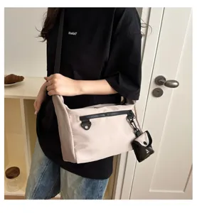 Detailed view of casual minimalist messenger bag with front zipper pocket and mini pouch.