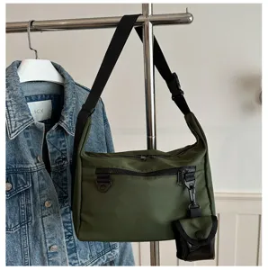 Green nylon messenger bag with small pouch detail and adjustable shoulder strap.