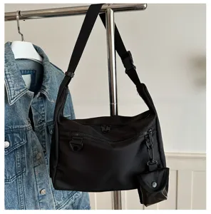 Black nylon messenger bag, casual crossbody shoulder bag with small pouch detail.