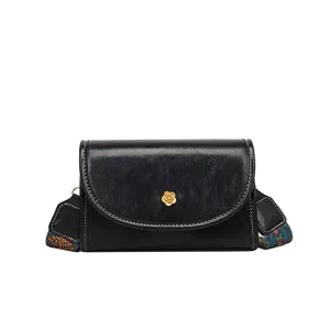 Black vintage shoulder bag with gold camellia flower clasp and ethnic wide strap main view
