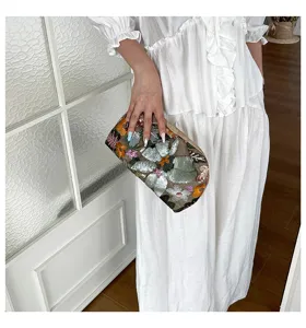 Detailopname van de schitterende geborduurde paillettenclutch met prachtig bloemenpatroon.