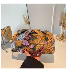 Gedetailleerd overzicht van de met pailletten geborduurde bloemenclutch met kleurrijk design.