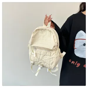 Casual mini backpack detail shot, beige nylon daily daypack with front pocket and cords.