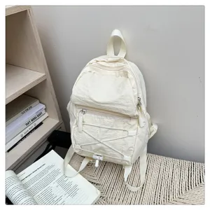 Casual lightweight backpack detail showing front zipper pocket and stylish elastic cord design.