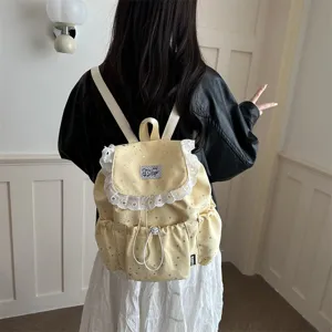 Vue de détail du sac à dos jaune à motif d'étoiles avec une jolie bordure en dentelle.