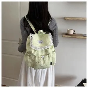Vue détaillée du sac à dos vert clair avec de jolies volants en dentelle et étoiles.