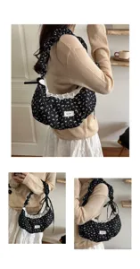 Borsa a tracolla nera con stampa floreale, bordo in pizzo bianco e manico arricciato.