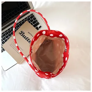 Detailed top-down view of red polka dot nylon bucket bag showing interior lining and handle.