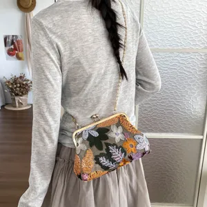 Detail shot of a Chinese style sequin embroidered shoulder bag with metallic clasp frame.