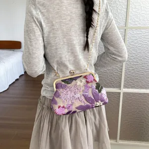 Detailed view of Chinese style floral sequin embroidery kiss lock shoulder bag with chain strap.