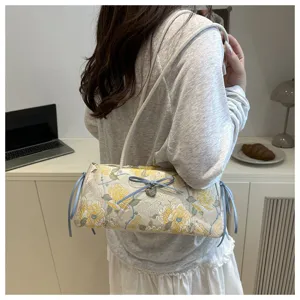 Detailed shot of a stylish Chinese style embroidered shoulder bag with floral pattern and ribbons.