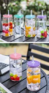 Glass straw cup detail view featuring colorful lids, clear cup body filled with fruit and ice.
