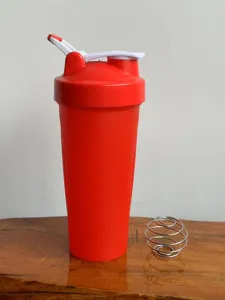 Red shaker cup detail view featuring durable plastic body and stainless steel mixing ball.