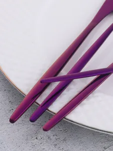 Close up of sleek purple stainless steel cutlery set detail, elegant thin handle tableware.