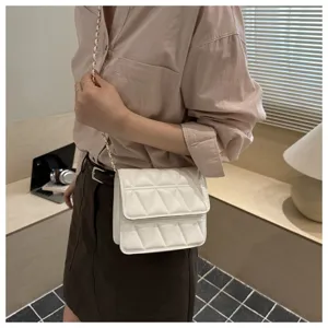 Close-up detail shot of a chic white quilted chain shoulder bag, stylish minimalist design.