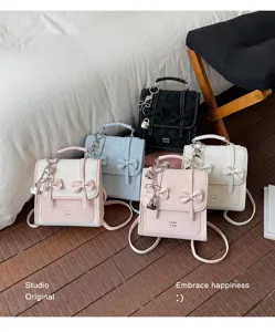 Grazioso zainetto mini con dettaglio di fiocco, colori a contrasto eleganti e charm con lucchetto.