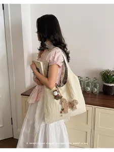 Vue détaillée du sac cabas fourre-tout vintage élégant avec broderie de cheval et pendentif.