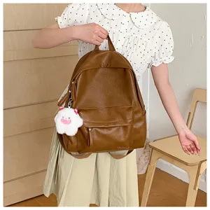 Vue détaillée du sac à dos en cuir marron rétro avec charm en peluche, style quotidien.