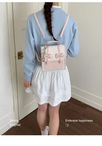 Vista dettagliata del grazioso zaino rosa e bianco con fiocco indossato dalla modella.