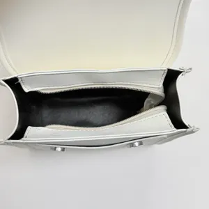 Zaino minimalista bianco da donna vista dall'alto mostra struttura interna e tasche.