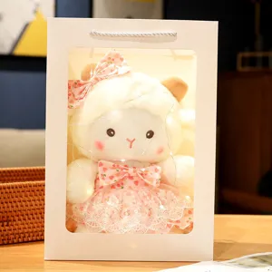 Cute sheep plush toy in gift box with string lights, pink strawberry dress detail.