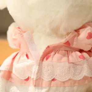 Cute lamb plush toy detail view showing sweet pink heart dress and delicate lace trim.