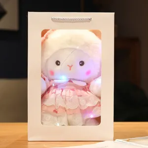 Cute lamb plush doll detail shot in gift bag with fairy lights, soft toy gift idea.