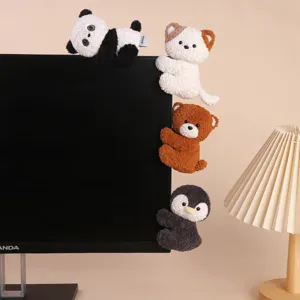 Close up detail of cute animal plush clip toys hanging on monitor edge office desk decor.