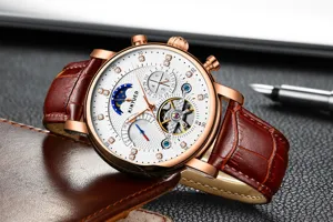 Detail heren mechanisch horloge, roségouden kast, witte strass wijzerplaat, bruin leer.