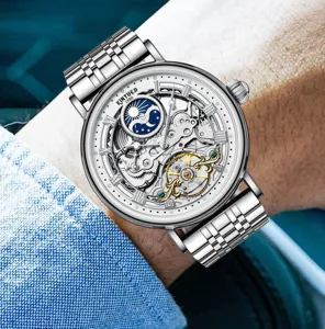 Nahaufnahme einer silbernen automatischen Uhr mit Skelettzifferblatt am Handgelenk.