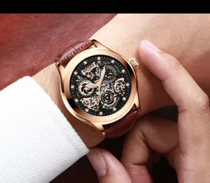 Reloj mecanico automatico para hombre con esfera esqueletica caja dorada y correa de cuero.