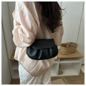 Detail view of the stylish black pleated shoulder bag, featuring fine texture and hardware.