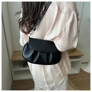 Detailed view of the black pleated leather saddle bag, stylish commuter shoulder handbag.