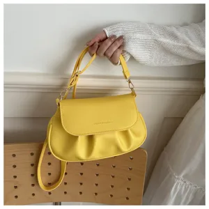 Yellow pleated shoulder bag for women, stylish crossbody saddle bag with adjustable strap.