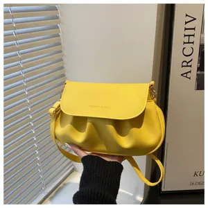 Yellow ruched shoulder bag detail view, stylish women crossbody saddle bag with flap and metal accents.