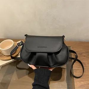 Black pleated crossbody saddle bag for women, stylish minimalist shoulder bag with flap design.
