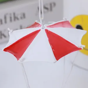 Gros plan détaillé d'un mini ornement suspendu de parapluie de Noël en rouge et blanc.