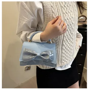 Detail shot of the light blue handbag with a stylish bow, showcasing fine craftsmanship.