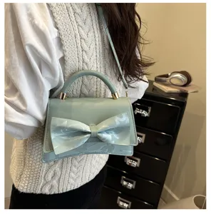 Light green women's handbag with bow detail, stylish crossbody bag for daily wear and fashion.