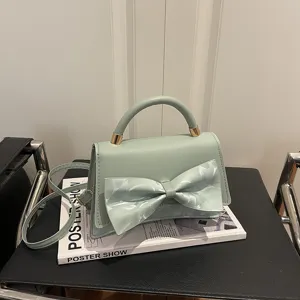 Chic light green top handle crossbody bag for women with elegant bowknot design main view