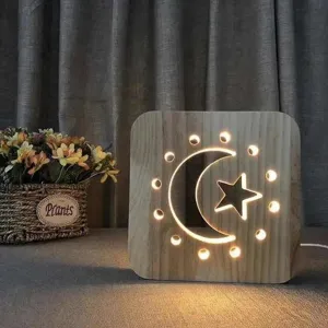 Wooden LED night light detail shot showing the hollowed moon and star design on a cozy desk setup.