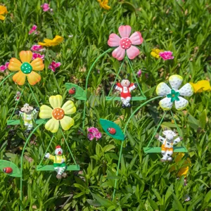 Detail van metalen tuinsteker met dierenschommels en kleurrijke bloemen voor plantenpotten.